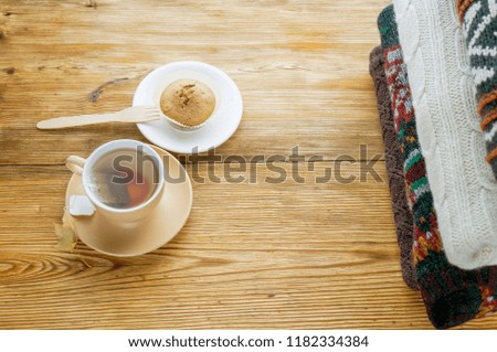 Cup of tea and pile of sweaters, top view