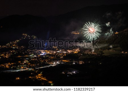 celebration with fireworks upon a mountain town at night