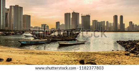 A picture of one of the marinas in the Sharjah City in UAE, where overlooking the towers on the sea at sunset. An exquisite view of architectural and civilization development.