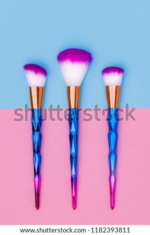 Cosmetic Makeup Brush Set. Professional Make up Brushes on blue pink background, close up, flat lay