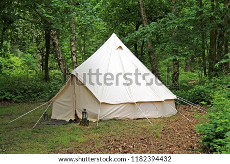 A Vintage White Canvas Tent in a Woodland Setting. Royalty-Free Stock Photo #1182394432
