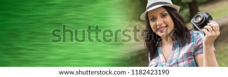 Portrait of beautiful young woman taking pictures in a park