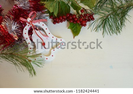 Christmas border. Christmas gifts, fir branches on wooden white background. Flat lay, top view, copy space. wooden toy bell