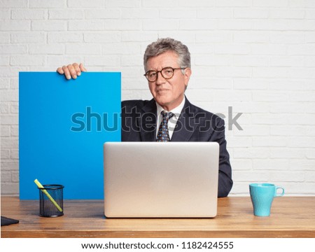 senior businessman working  with his laptop and showing an empty place  holding a placard