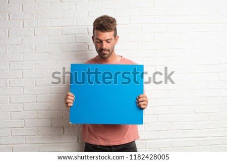 young handsome cool man holding a placard