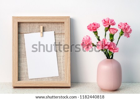 Terrazzo desk with wooden frame mockup and pink carnations in a notched vase