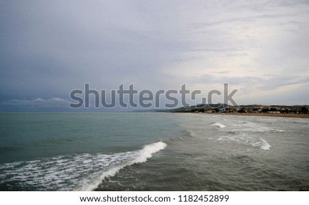 Abruzzo, Italy, a long wave of adriatic sea near Giulianova on a stormy day. The adriatic coast in background