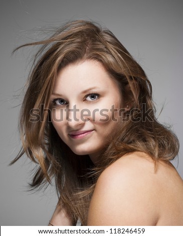  portrait of a young beautiful woman with brown hair against gray background