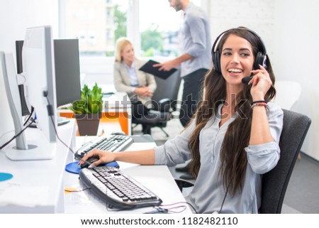 Attractive telephone worker customer service operator woman working in the office Royalty-Free Stock Photo #1182482110