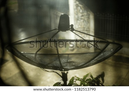 Abstract silhouette picture of satellite receiver with heavy raining at night