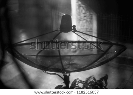 Monochrome abstract silhouette picture of satellite receiver with heavy raining at night