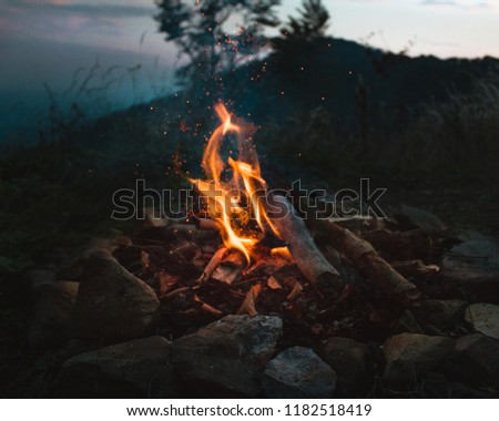 Camp fire with sparks at dusk, twilight