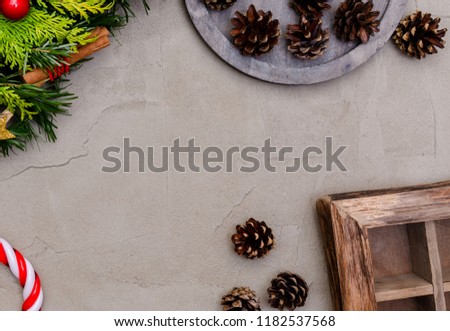 Top view, copy space. Traditional green christmas wreath with pine cones, thuja branches, candy Cane with Red Bow gift on gray concrete background. Festive decoration. Holiday concept.
