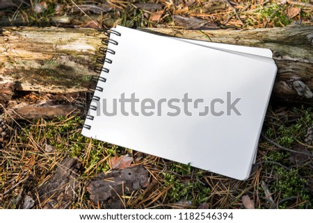 Notepad white paper on stem of the tree as a sign or mockup with ring bond