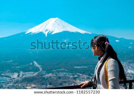 Asian young woman tourist backpacker look at fuji mountain and village view in Japan, clear sky with blank copy space