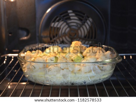 Vegetables in glasswares is baked in an oven.