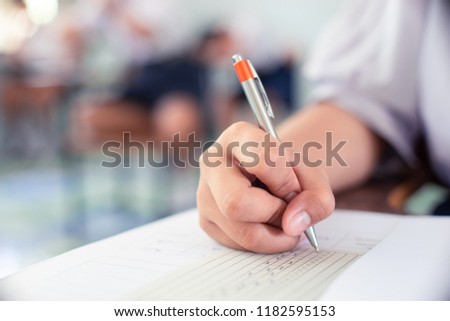 Students writing and reading exam answer sheets exercises in classroom of school with stress.