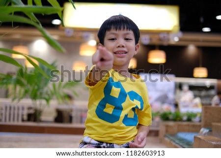 Young confident teenager guy smiling and pointing at camera