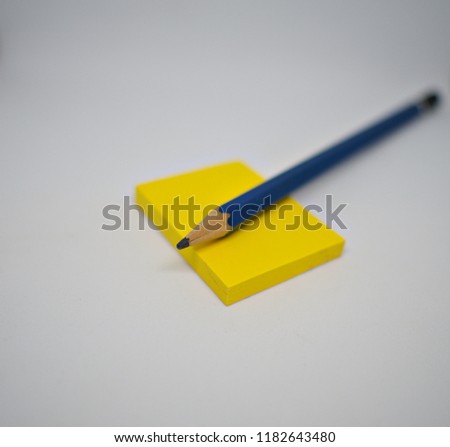 Yellow sticky note under the pencil waiting for wrting down short note.
