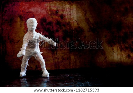 Dramatic Halloween background scary mummy character on vintage wall. Copy space 