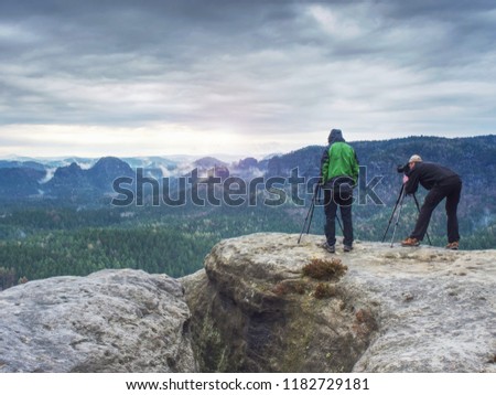 Outdoor shot of talented hobby photographers taking pictures  in rocks.  Camp, adventure, trip and traveling concept.