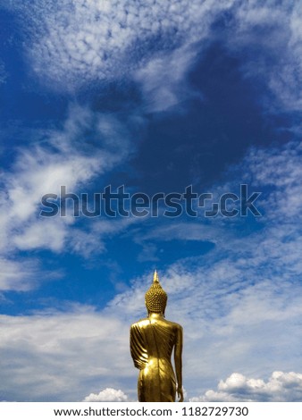 Golden Buddha statue at Wat Phra That Kao Noi with colorful clouds sky in morning, Nan Province, Thailand
