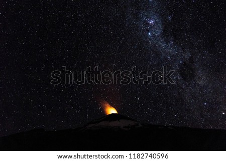 Starry night sky and burning Villarrica volcano in Villarrica National Park, Chile