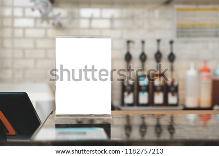 Menu Card Holder with white sheet of paper on table in cafe.Card display Promotion and Information for customer,Picture stand,Sign Holder and Photo Frame Mock up template.