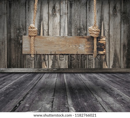 Old wooden banner hanging on a dark grungy room and copy space