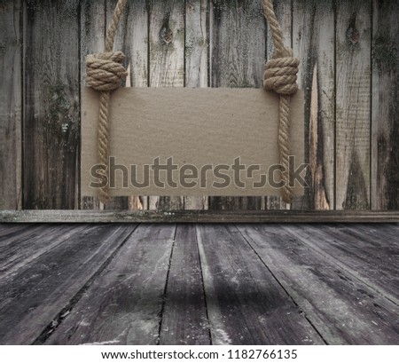 Old wooden banner hanging on a dark grungy room and copy space
