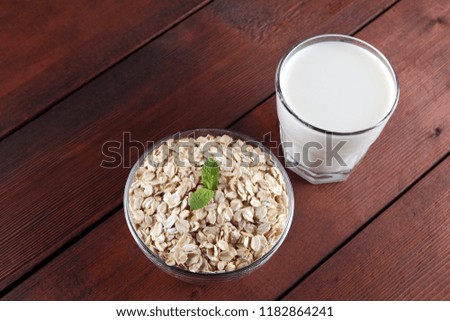 Oatmeal, milk and mint. Oat flakes on wooden boards. Milk and oatmeal for breakfast. Healthy food. Vegetarian food. Minimalism