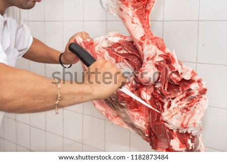 butcher cutting a large piece of meat