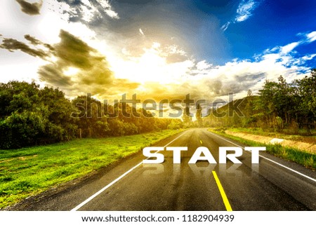 The word start written on highway road in the middle of empty asphalt road with golden sunset and beautiful blue sky. Concept for new start.