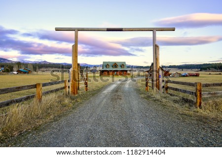 Entry gate to a nice wooden ranch home with beautiful landscape. Northwest, USA. Royalty-Free Stock Photo #1182914404