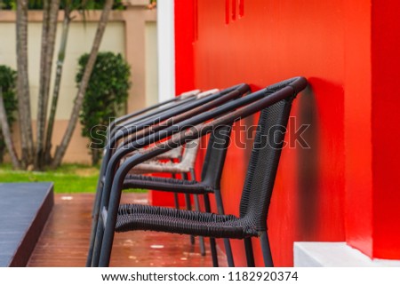Selective focus of abstract chairs with the red wall at pool
