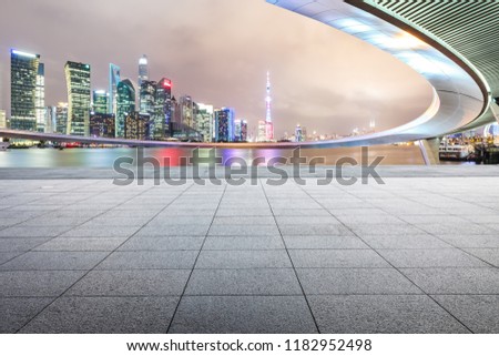 Empty square floor and modern city buildings with bridge in Shanghai at night