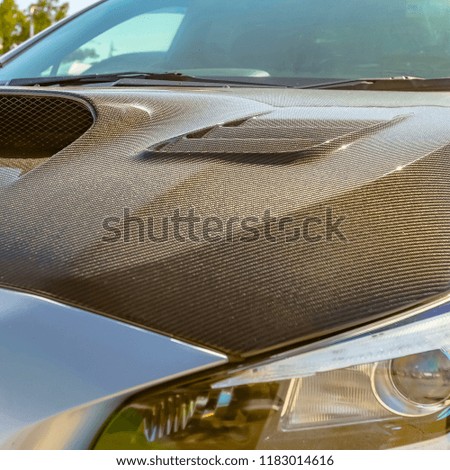 Carbon fiber hood and tallight of a silver car