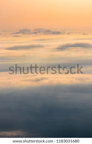 Telephoto-panoramic landscape above clouds with mountains peaks.