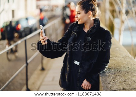 woman using her cell phone while walking throughthe streets of Paris France