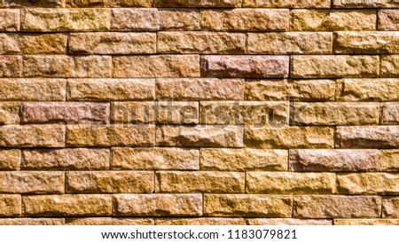 Pattern of brown Modern stone Brick Wall Surfaced. wall background photograph. Rough textured bricks in farmhouse style, an authentic photograph shot outdoors with natural light.