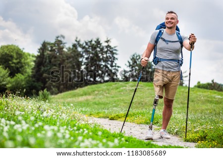 Full length of a nice positive young man with prosthesis having a walk outdoors and enjoying his hobby Royalty-Free Stock Photo #1183085689