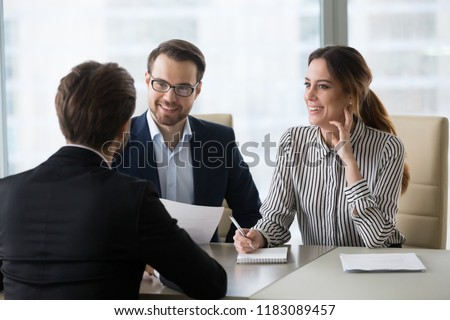 Smiling diverse HR managers satisfied about male job employee, have positive first impression of candidate, happy employers listen to applicant at interview excited of candidature. Recruitment concept Royalty-Free Stock Photo #1183089457
