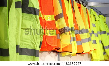 Car driver and road workers special clothing - new bright workwear jackets with reflective stripes in showroom Royalty-Free Stock Photo #1183157797
