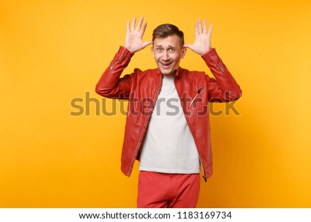 Portrait vogue smiling handsome young man 25-30 years in leather jacket, t-shirt standing isolated on bright trending yellow background. People sincere emotions lifestyle concept. Advertising area