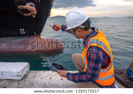 harbor master supervisor is survey and inspection of the safty berthing along side of the ship vessel mooring in port terminal, report and communication by radio walkie talkie and device swift on line Royalty-Free Stock Photo #1183172617