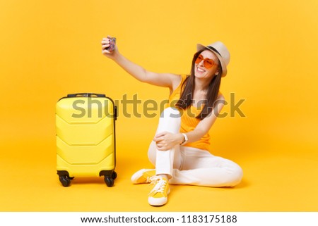 Tourist woman in summer casual clothes, hat doing selfie shot on mobile phone isolated on yellow orange background. Female passenger traveling abroad to travel on weekends getaway. Air flight concept