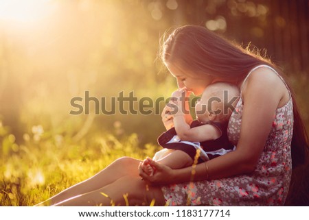 Mom kisses the leg of her little daughter