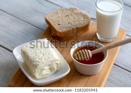 Clotted cream (butter cream) for Turkish breakfast / Kaymak, honey and glass of milk Royalty-Free Stock Photo #1183205941