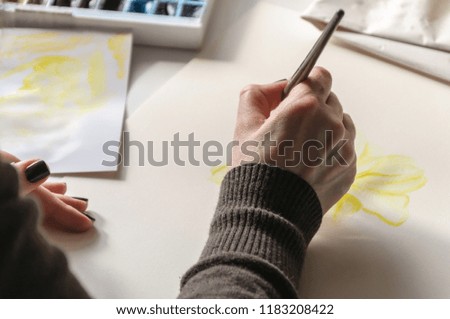 Close up section of female painter artist - hand leading brush. Woman painting a picture
