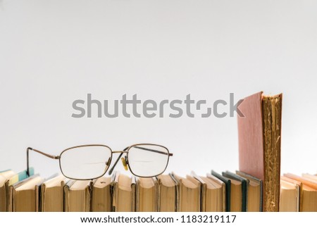 Open book, hardback hard cover colorful books with reading glasses on the side. Back to school. Copy space for text. Education, studying, learning, business concept